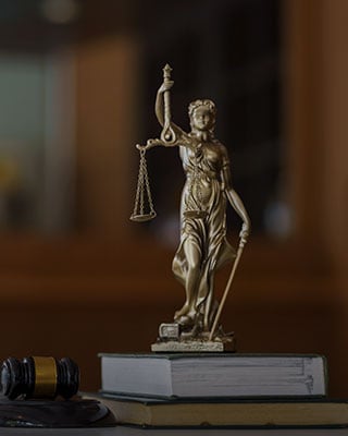 A lawyer statue on books symbolizing legal expertise - The Law Offices Of Matthew Cargal