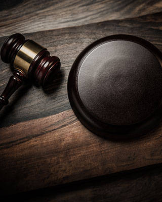 A judge's gavel and a wooden plate on a table - The Law Offices Of Matthew Cargal